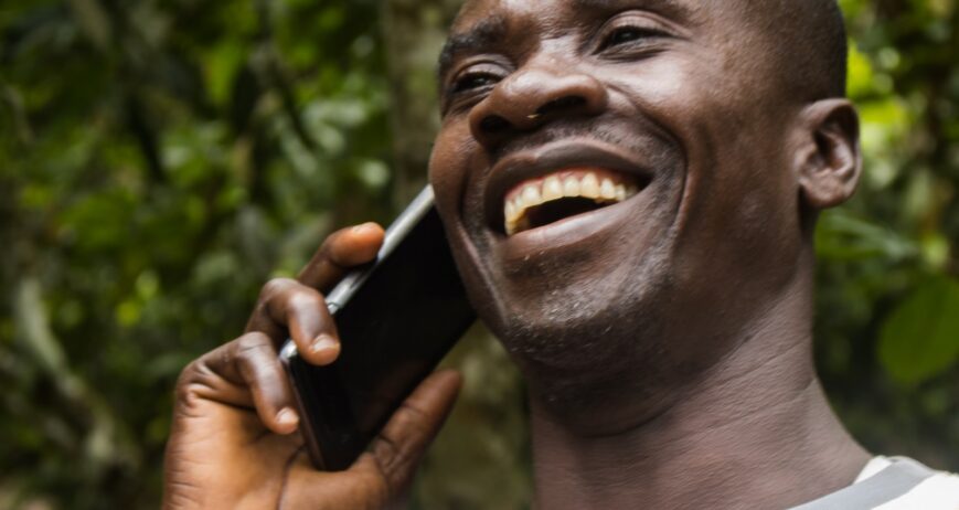 Farmer using a mobile phone among cocoa trees